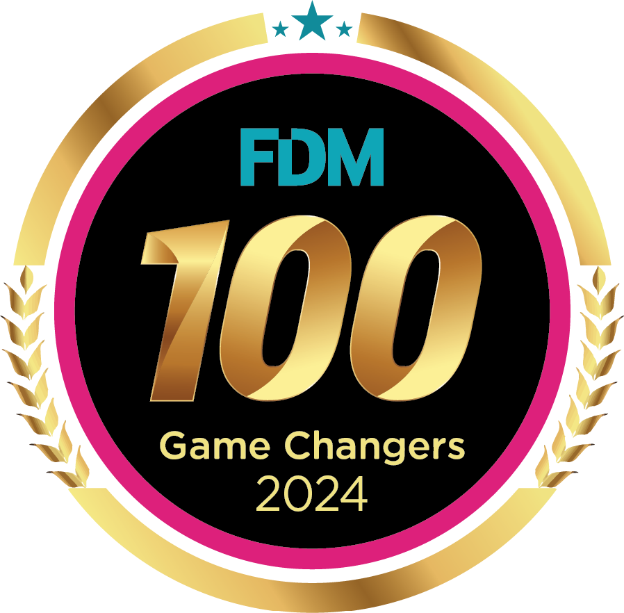 Logo for "FDM 100 Game Changers 2024" with gold lettering, a star, and laurel accents on a circular background.